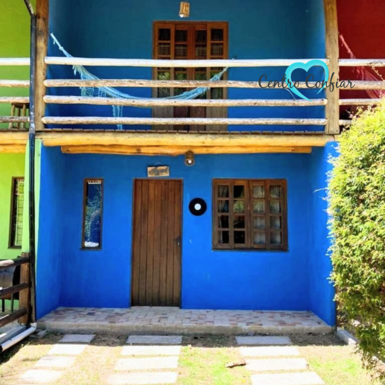 Chalé azul com sacada de madeira e jardim frontal na clínica de recuperação em Imbituba – Praia do Rosa SC