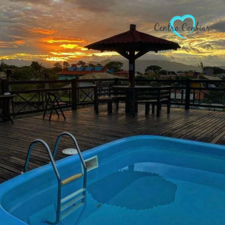 Piscina em deck de madeira com vista para o pôr do sol em clínica de recuperação em Imbituba – Praia do Rosa SC