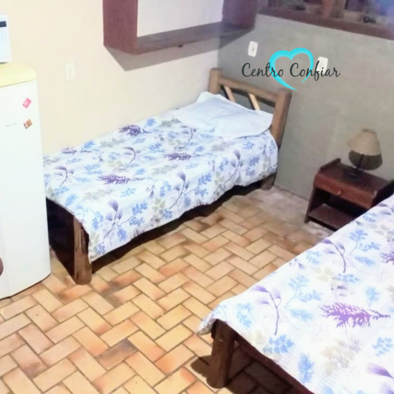 Quarto com duas camas de solteiro, frigobar e micro-ondas em clínica de recuperação em Imbituba – Praia do Rosa SC